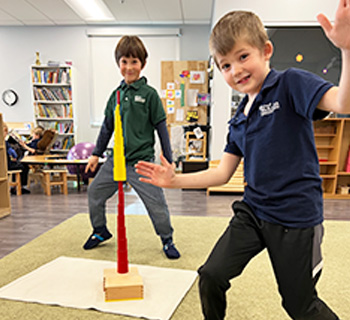 Two boys balancing toys in the classroom