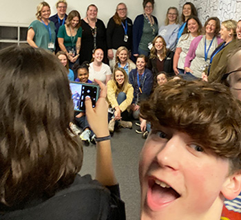Student taking a selfie with a group of other students