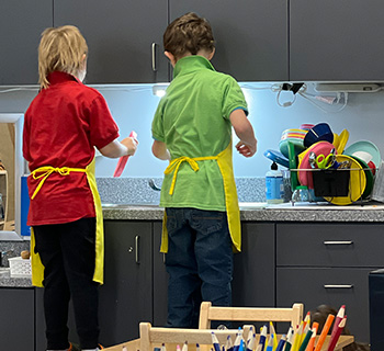 Two elementary students working at a sink together
