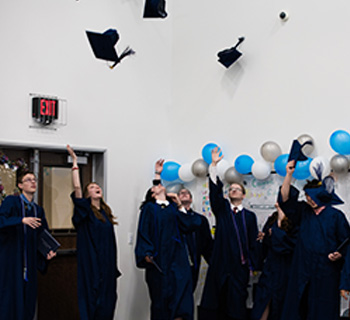 Group of graduates throwing caps in the air